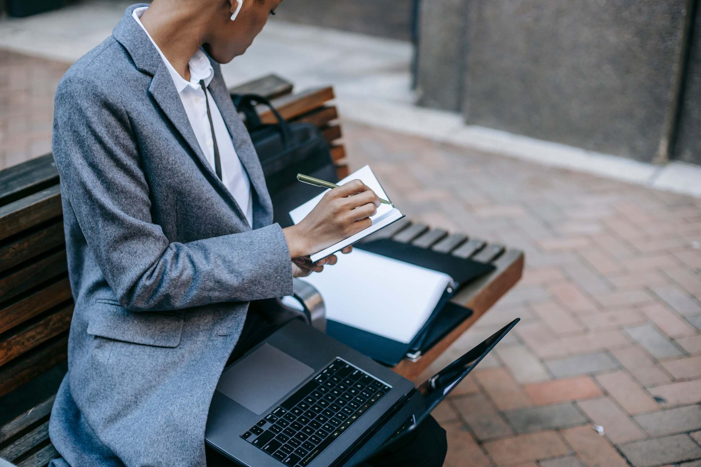 Open laptop on a desk beside a window with city buildings outside, working remotely in daylight